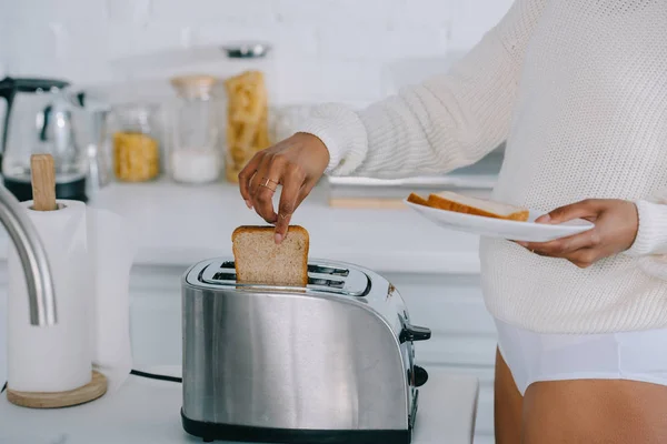 Corte tiro de mulher afro-americana em roupa interior e suéter fazendo torradas na cozinha — Fotografia de Stock