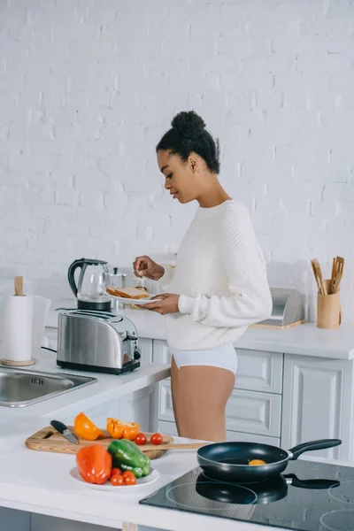 Привлекательная молодая женщина делает тосты на кухне — стоковое фото