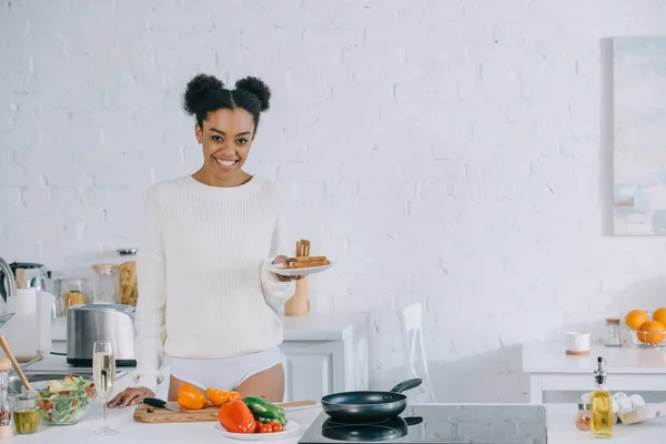 Счастливая молодая женщина с пачкой ломтиков хлеба на тарелке на кухне — стоковое фото