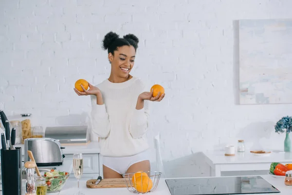 Beautiful young woman with fresh healthy oranges at kitchen — Stock Photo