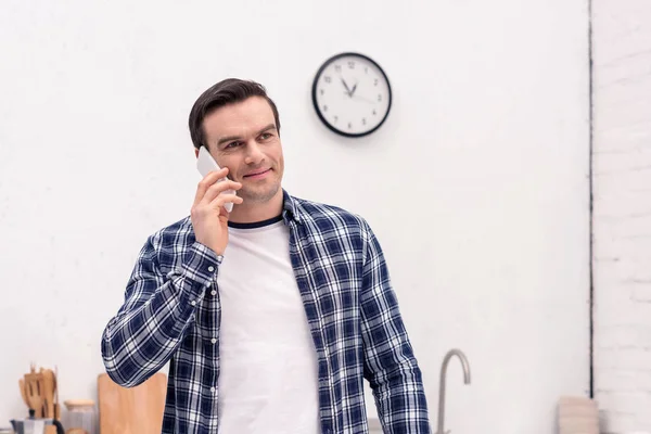 Happy adult man talking by phone at kitchen — Stock Photo