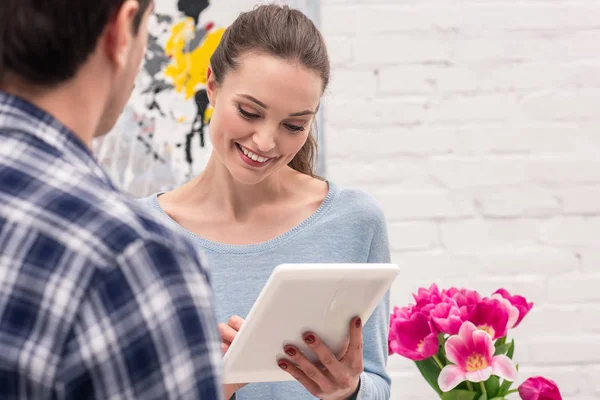 Happy adult woman using tablet near her boyfriend at home — Stock Photo