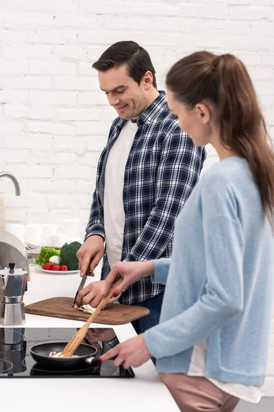 Feliz pareja adulta cocinando juntos una cena saludable - foto de stock