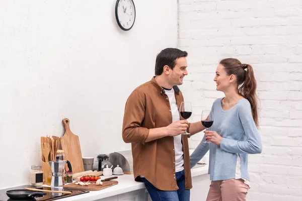 Красива доросла пара в окулярах з вином проводить час разом на кухні — стокове фото