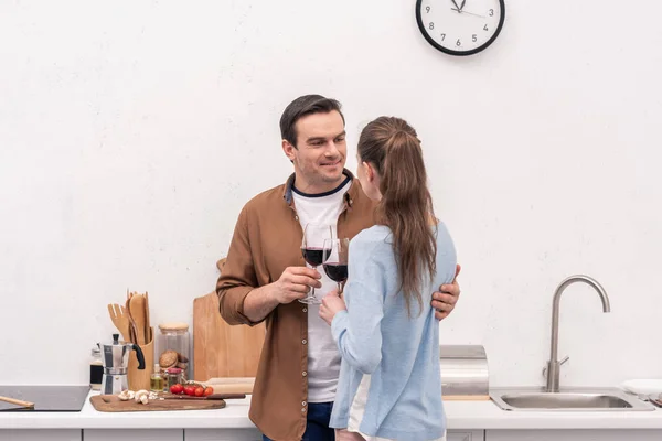 Beau couple adulte cliquetis verres de vin à la cuisine — Photo de stock