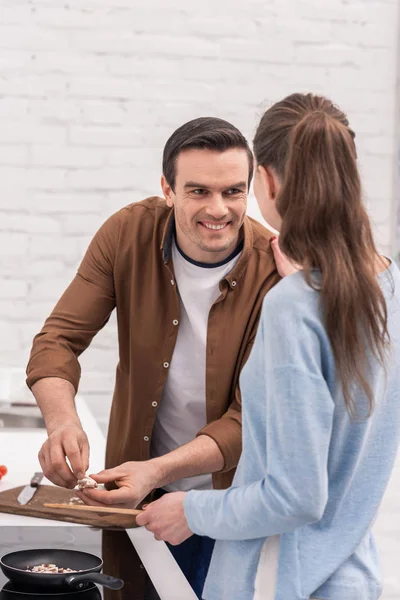 Feliz pareja de adultos cocinar la cena juntos en la cocina - foto de stock