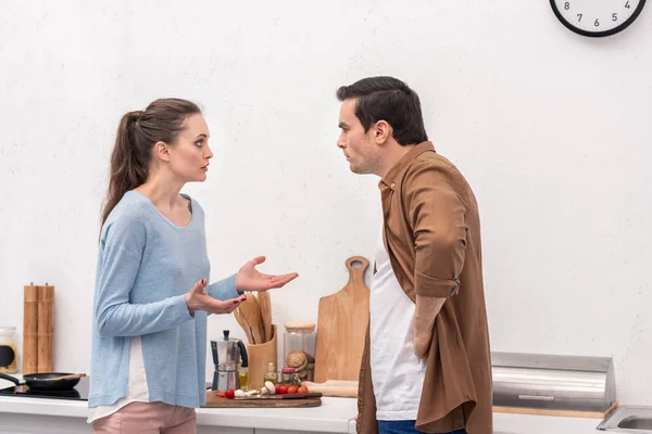 Vista lateral de pareja adulta teniendo pelea en la cocina - foto de stock