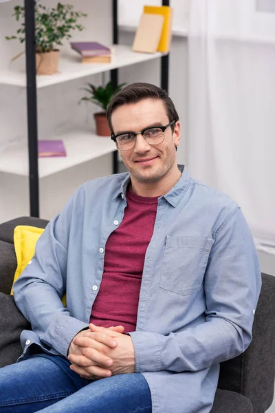 Happy adult man relaxing on couch at home and looking at camera — Stock Photo