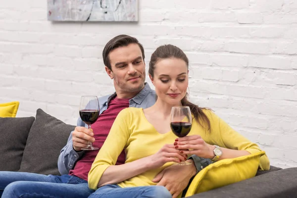 Glückliches erwachsenes Paar mit einem Glas Rotwein, das Zeit miteinander zu Hause verbringt — Stockfoto