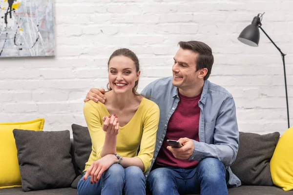 Glückliches erwachsenes Paar vor dem Fernseher zusammen auf der Couch — Stockfoto