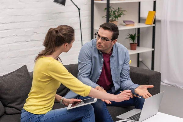 Hermosa pareja adulta trabajando con dispositivos en casa juntos - foto de stock