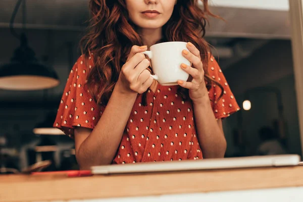 Tiro cortado de mulher com xícara de café aromático em mãos no café — Fotografia de Stock