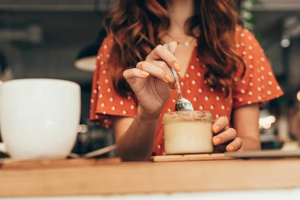 Vista parcial de la mujer comiendo sabroso soufflé en la cafetería - foto de stock