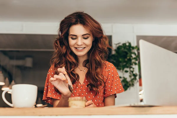 Retrato de la mujer sonriente comiendo sabroso soufflé en la cafetería - foto de stock