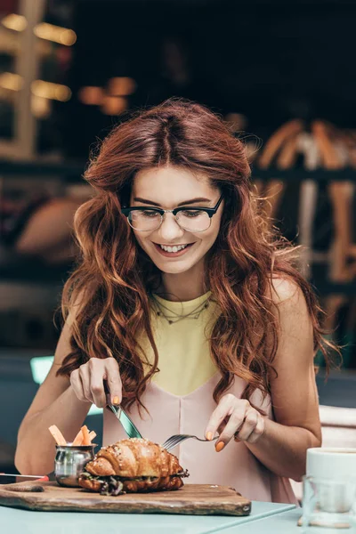 Retrato de mulher sorridente em óculos tomando café da manhã sozinha no café — Fotografia de Stock