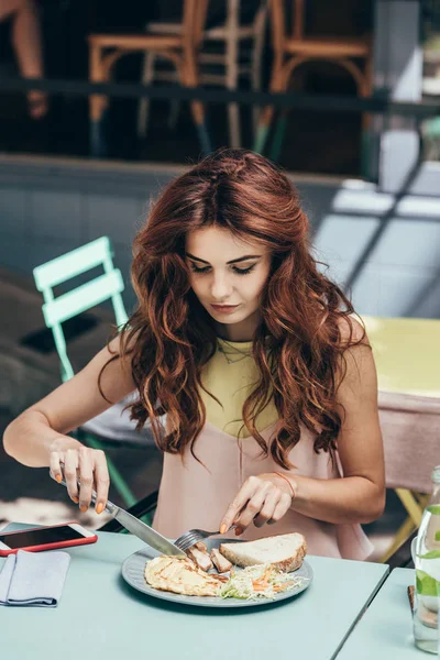 Porträt einer jungen Frau, die allein im Restaurant zu Mittag isst — Stockfoto