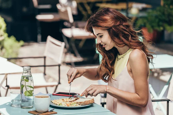 Side view of young woman having lunch alone in restaurant — Stock Photo