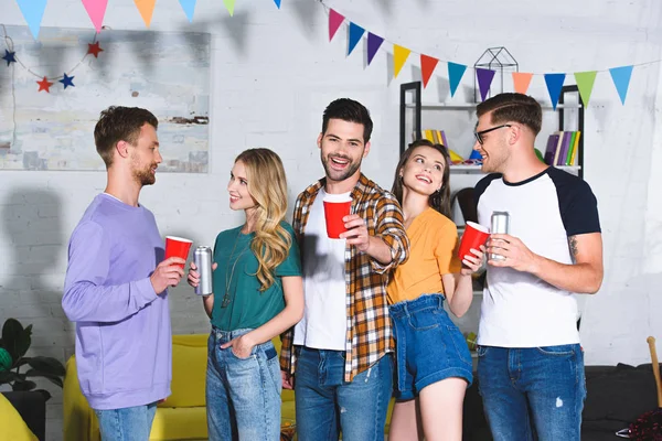 Fröhliche junge Freunde, die Bier trinken, während sie gemeinsam auf der Heimparty Spaß haben — Stockfoto