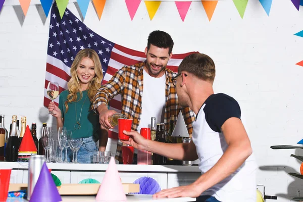 Felizes elegantes jovens amigos bebendo vinho e festejando em casa — Fotografia de Stock