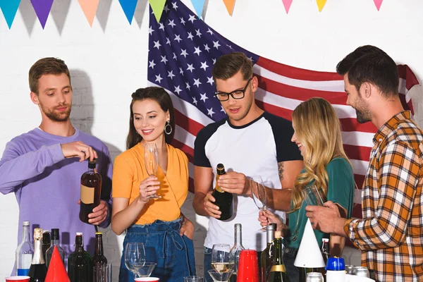 Щасливі молоді чоловіки і жінки друзі п'ють алкогольні напої на домашній вечірці — Stock Photo