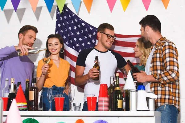 Heureux jeunes amis boire des boissons alcoolisées à la fête à la maison — Photo de stock