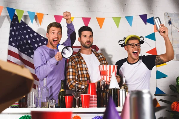 Excited young men screaming and having fun while partying at home — Stock Photo
