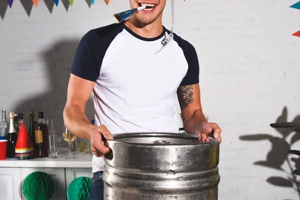 Corte tiro de feliz jovem segurando barril de cerveja em casa festa — Fotografia de Stock