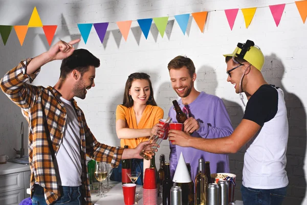 Heureux jeunes amis boire de l'alcool tout en faisant la fête ensemble — Photo de stock