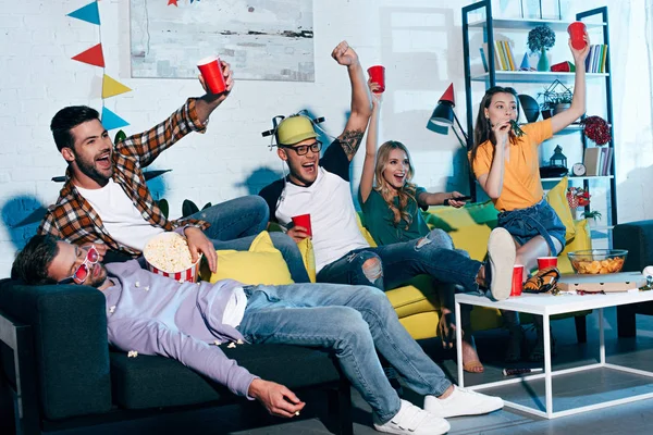 Cheerful young people drinking beer and having fun at home party — Stock Photo