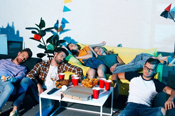 Високий кут зору п'яних молодих друзів чоловічої та жіночої статі спить після домашньої вечірки — стокове фото