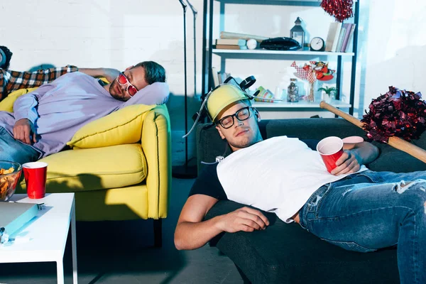 П'яні молоді чоловіки сплять на дивані після домашньої вечірки — стокове фото