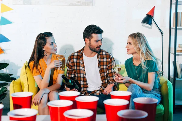 Visão de perto de copos de plástico e jovens bebendo vinho atrás — Fotografia de Stock