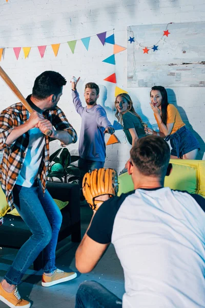 Jovens amigos felizes se divertindo e jogando beisebol na festa em casa — Fotografia de Stock