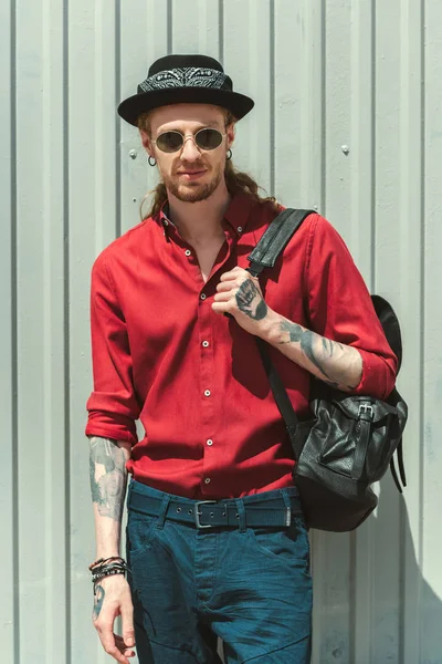 Bel homme en lunettes de soleil et chapeau avec sac à dos — Photo de stock