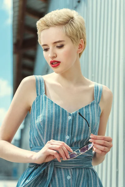 Chica atractiva con el pelo corto posando en vestido azul de moda - foto de stock