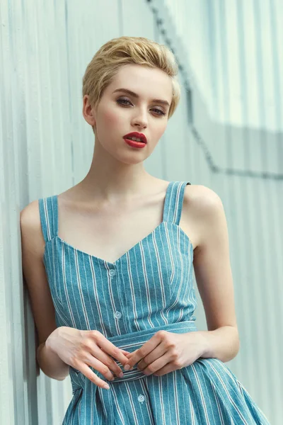 Hermosa chica con el pelo corto posando en vestido azul de moda - foto de stock