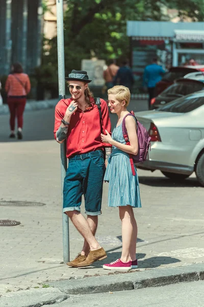 Stylish couple of tourists with backpacks walking in city — Stock Photo