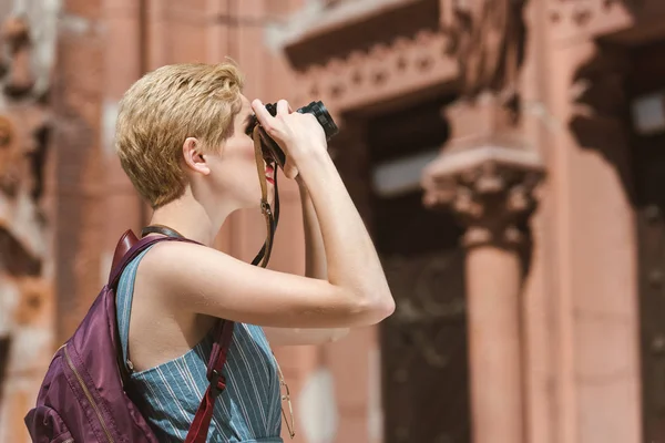 Turista donna con zaino scattare foto sulla macchina fotografica in città — Foto stock