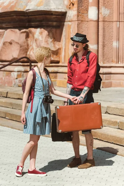 Пара путешественников с винтажными чемоданами в городе — стоковое фото