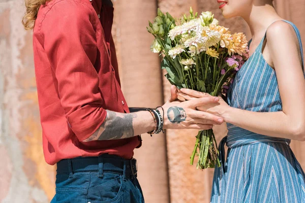 Vista cortada de casal com flores na data romântica — Fotografia de Stock