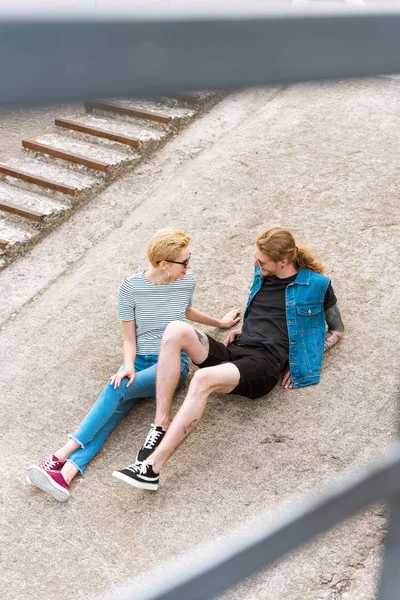 High angle view of boyfriend with tattoos and stylish girlfriend looking at each other — Stock Photo