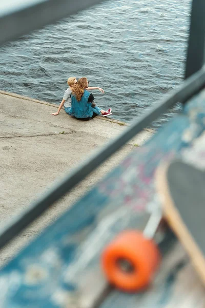 Vista a través de barandilla en pareja sentado y mirando al río - foto de stock