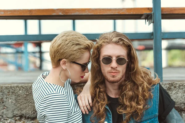 Portrait of stylish boyfriend and girlfriend standing near bridge — Stock Photo