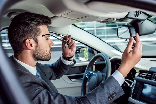 Side view of businessman wearing eyeglasses while sitting in car — Stock Photo