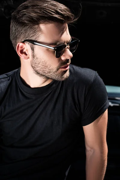 Vista lateral del hombre con estilo en gafas de sol delante del coche con capó abierto - foto de stock