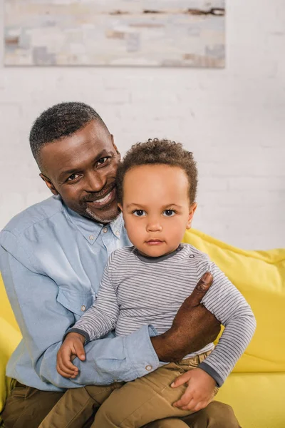 Heureux grand-père afro-américain et adorable petit-fils regardant la caméra — Photo de stock