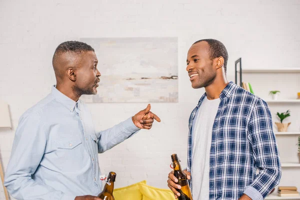 Happy father with smiling adult son drinking beer and talking at home — Stock Photo