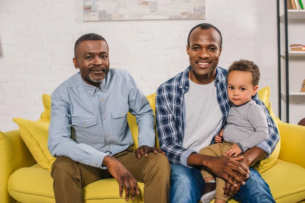 Feliz pai americano africano, avô e criança sentados juntos e olhando para a câmera — Fotografia de Stock