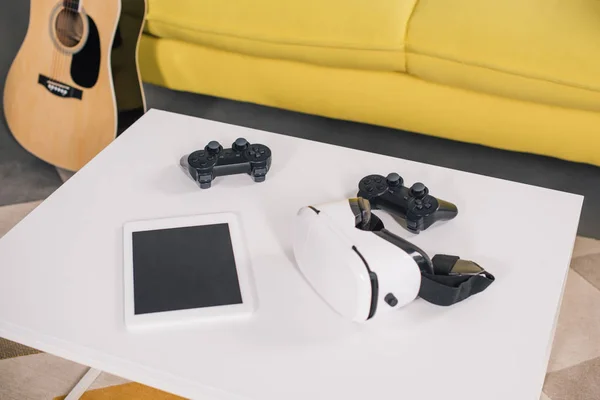 Visione ravvicinata delle cuffie per realtà virtuale, tablet digitale con schermo vuoto e joystick sul tavolo — Foto stock