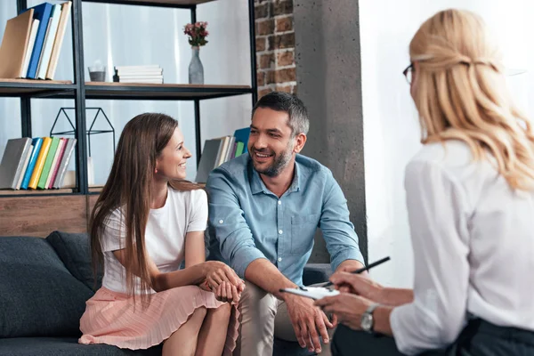 Vista posteriore del consulente femminile prendere appunti negli appunti sulla sessione di terapia di coppia — Stock Photo